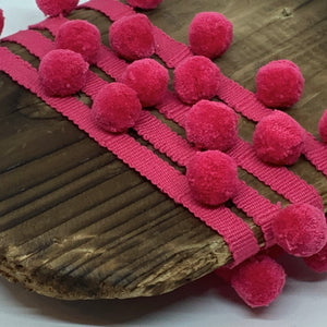 solid colour pomegranate pompom trim on matching braid