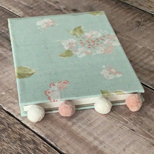 pompom and fabric covered notebook
